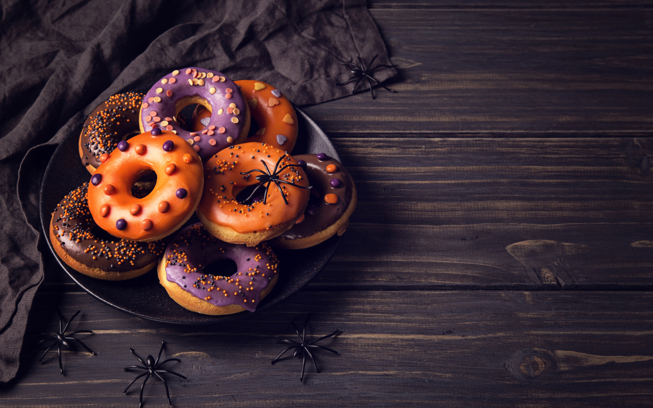 Пончики с глазурью на столе угощение на Хэллоуин 