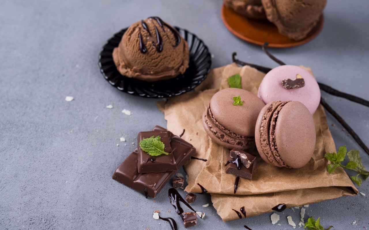 Печенье макарун на серой поверхности с мороженым и шоколадом