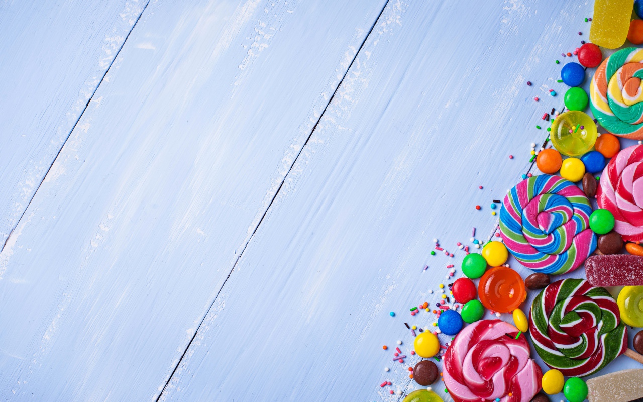 Разноцветные конфеты на голубом столе