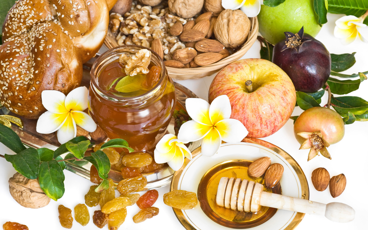 Орехи, мед, яблоки и выпечка с изюмом на столе к празднику