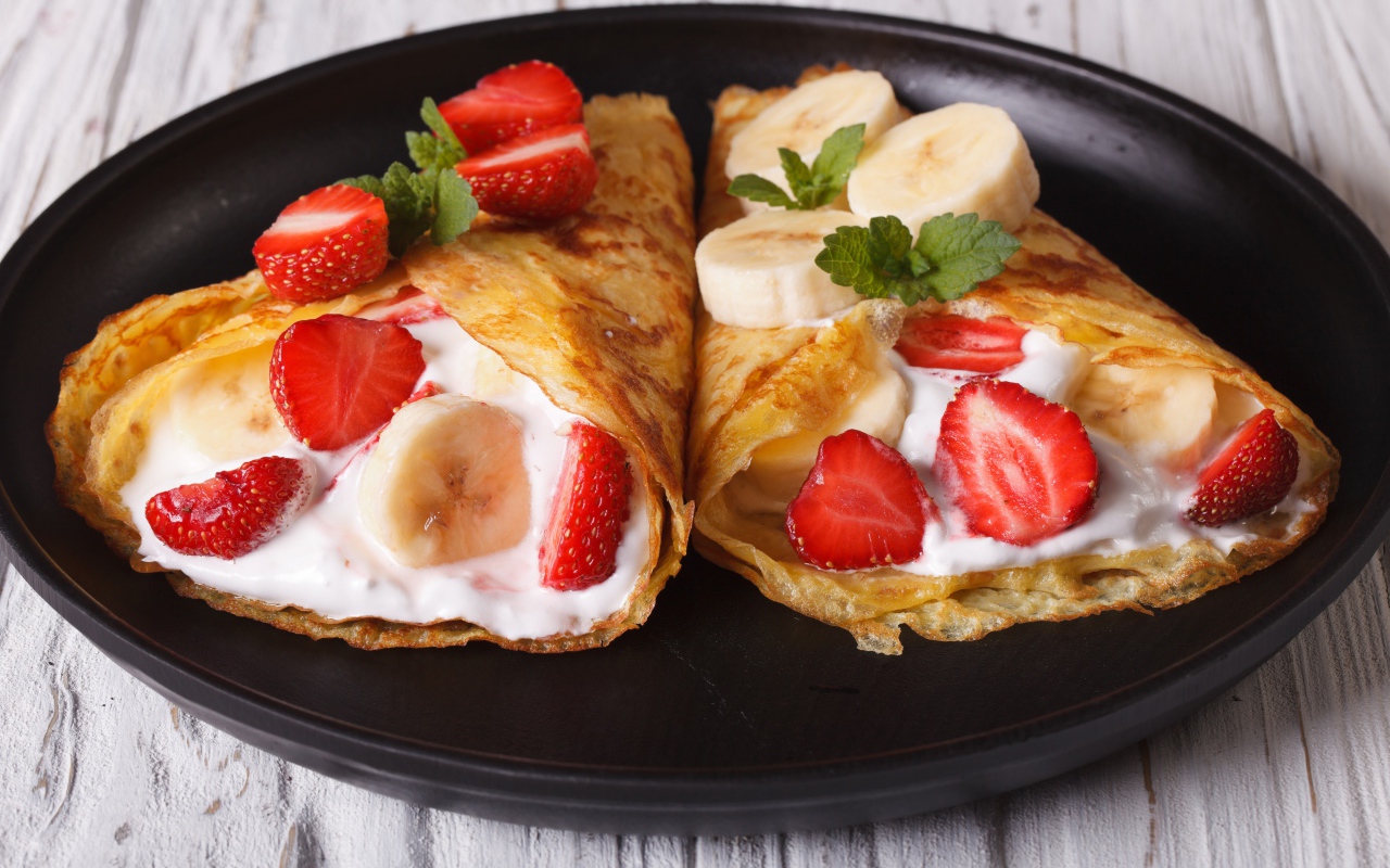 Блинчики со сметаной, бананами и клубникой на сковороде 