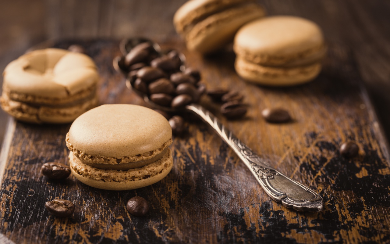 Печенье макарон на столе с ложкой и кофейными зернами