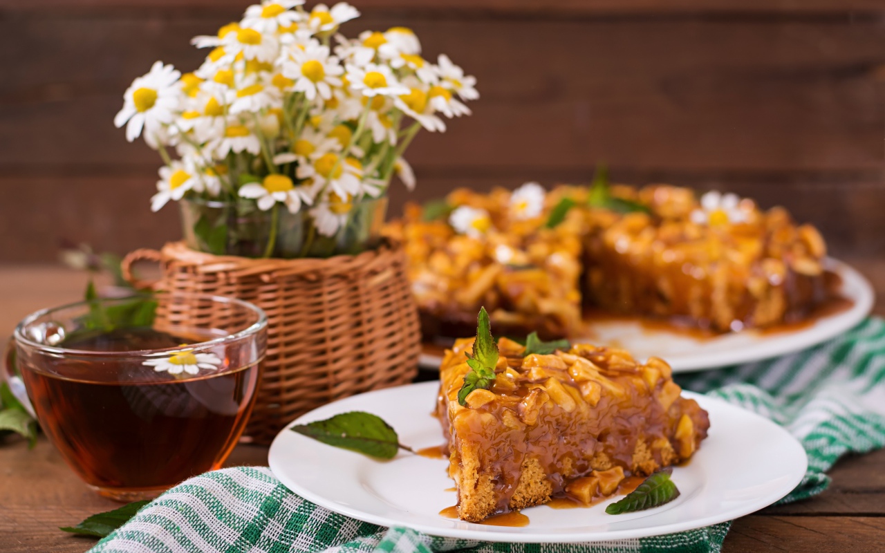 Пирог на столе с чаем и букетом ромашек