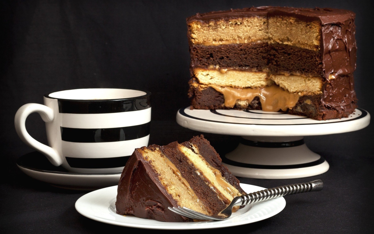 Бисквитный торт на столе с чашкой 