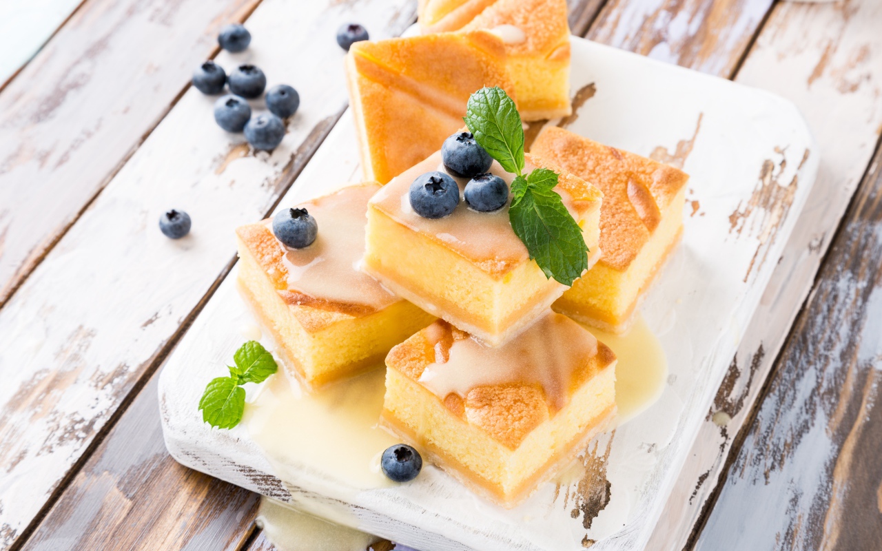 Бисквитные пирожные с сиропом и ягодами черники на столе