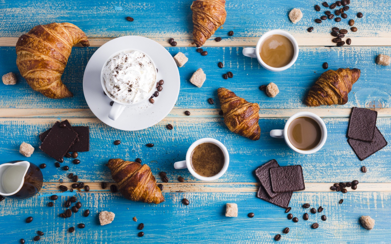 Сладости с кофе на голубом столе