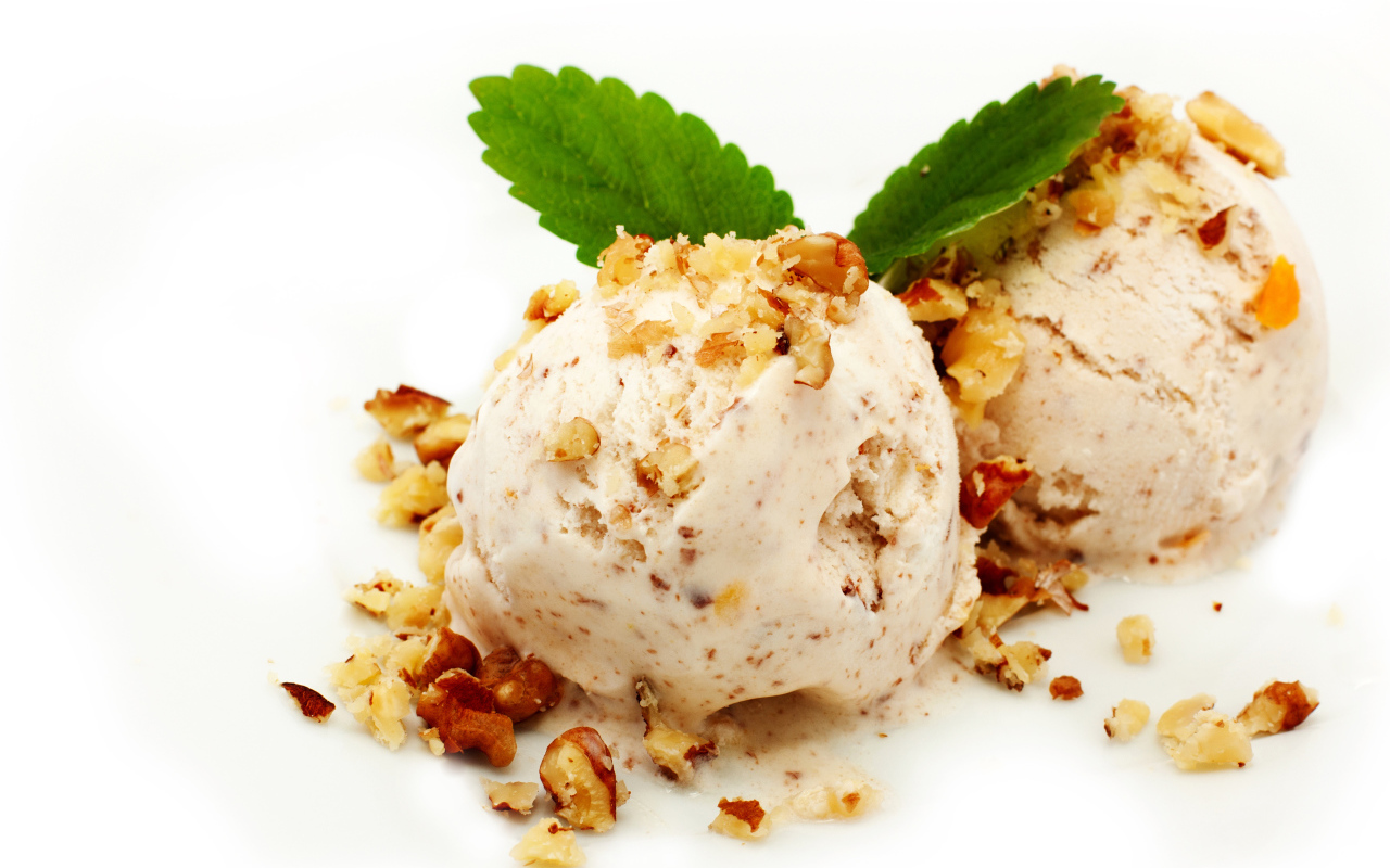 Два шарика мороженого с орехами на белом фоне