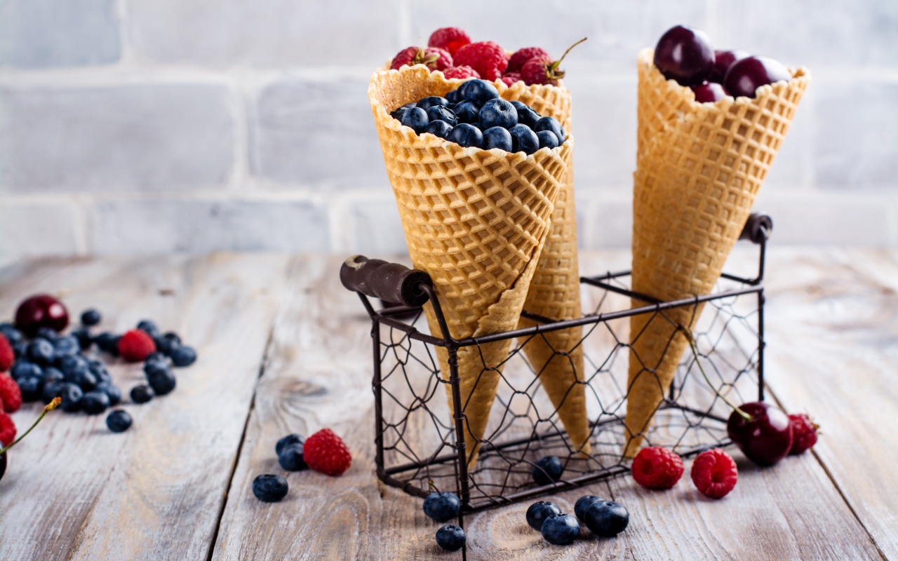Два вафельных рожка на столе с ягодами