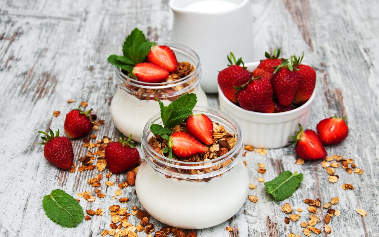 Yogurt in jars with oatmeal and strawberries