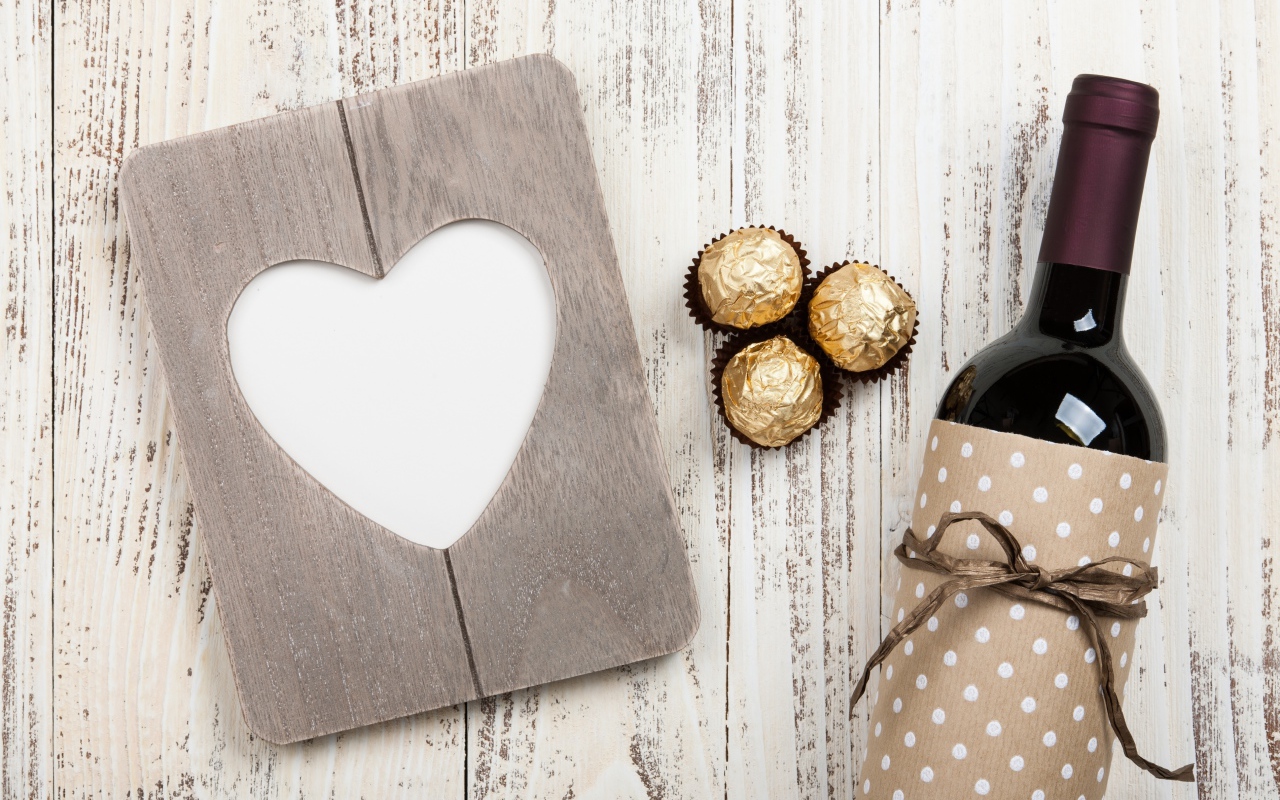 Бутылка вина на столе с конфетами и сердцем 