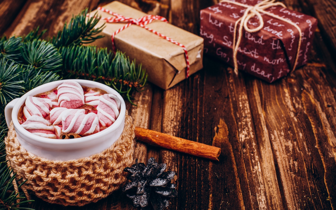 Чашка какао с маршмеллоу на столе с подарками