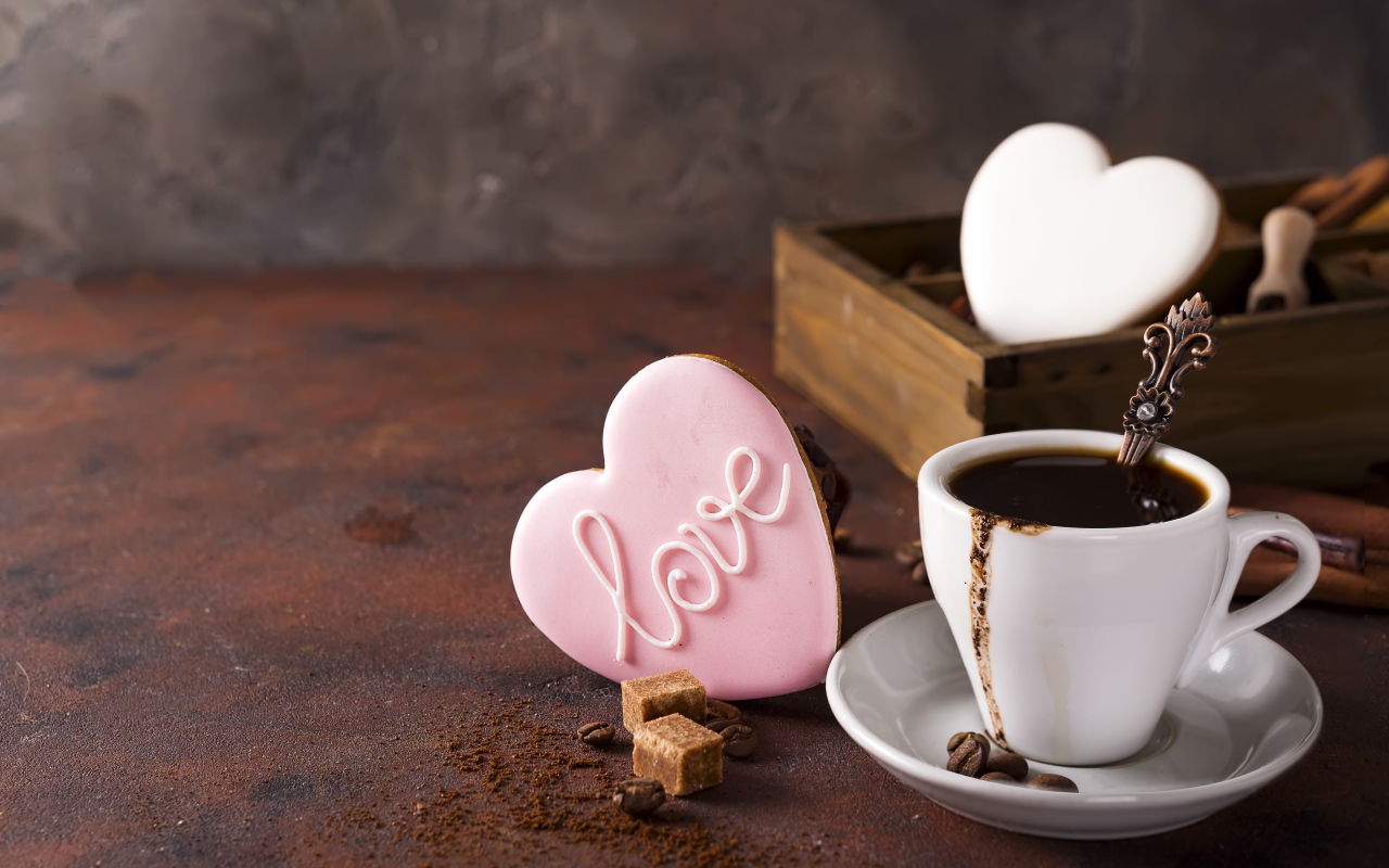 Чашка кофе на столе с сахаром и печеньем в форме сердца 