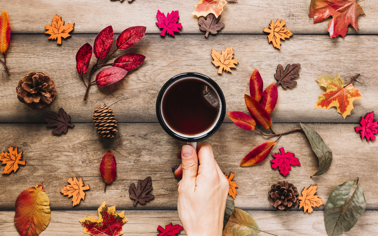 Кружка чая на столе с осенними листьями