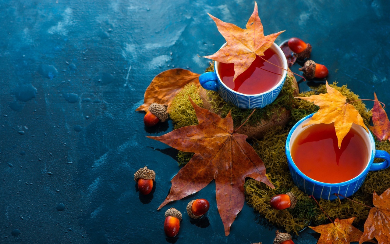 Чай на столе с осенними листьями и желудями 