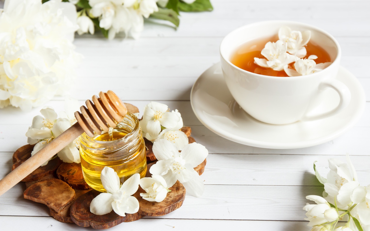 Чай на столе с медом и цветами жасмина
