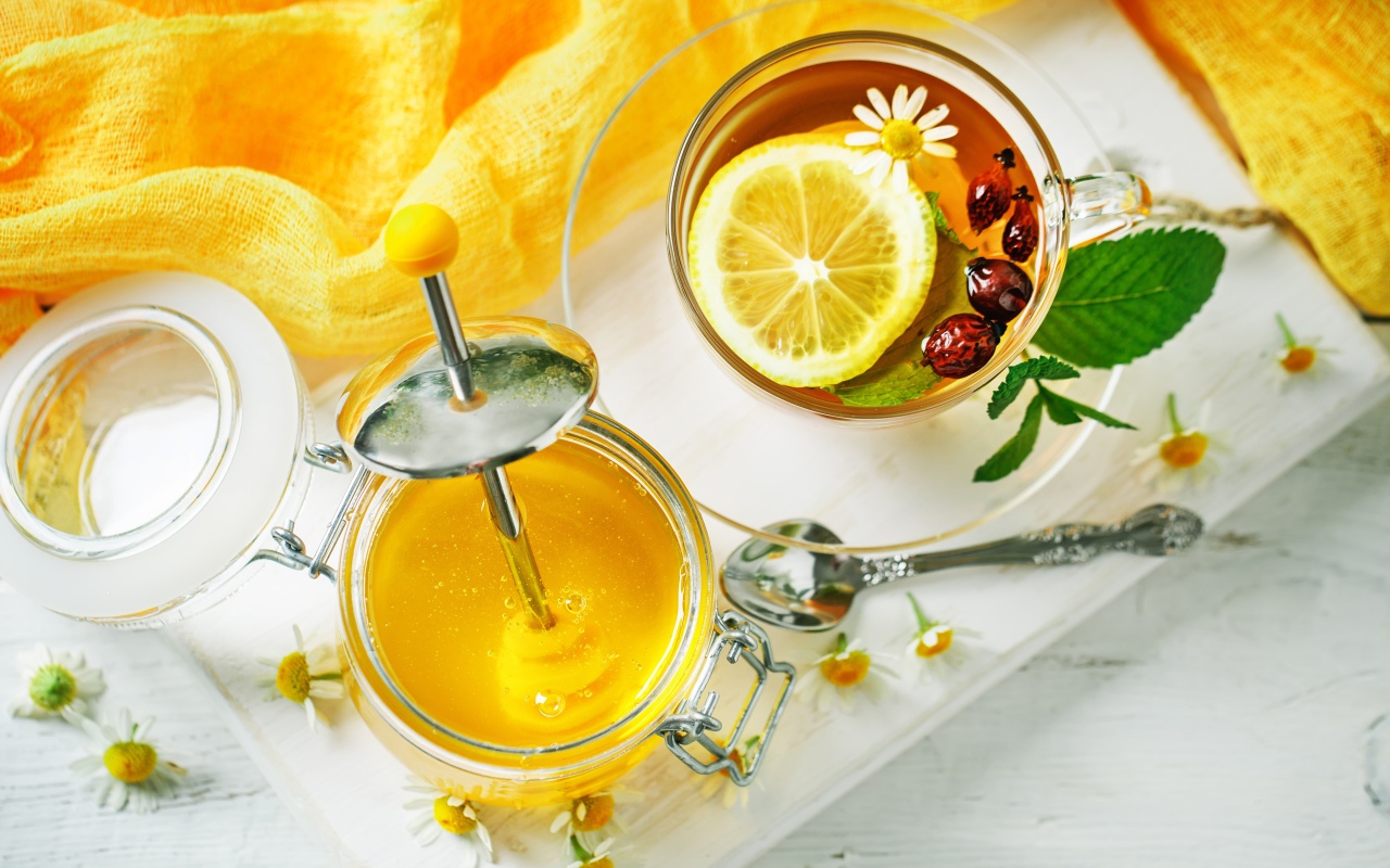 Чай с лимоном и шиповником на столе с медом