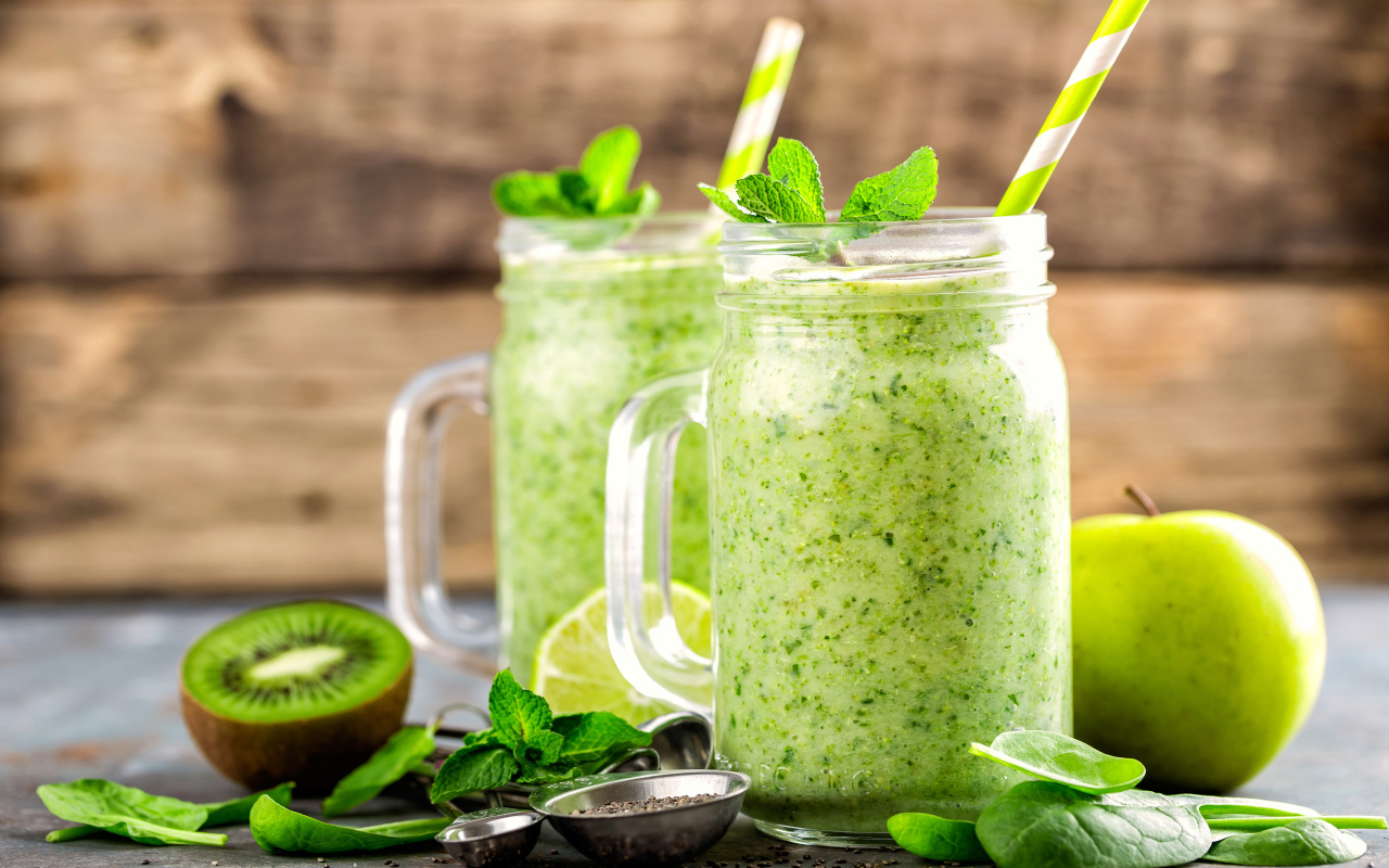 Два зеленых смузи на столе с киви, мятой и зеленым яблоком