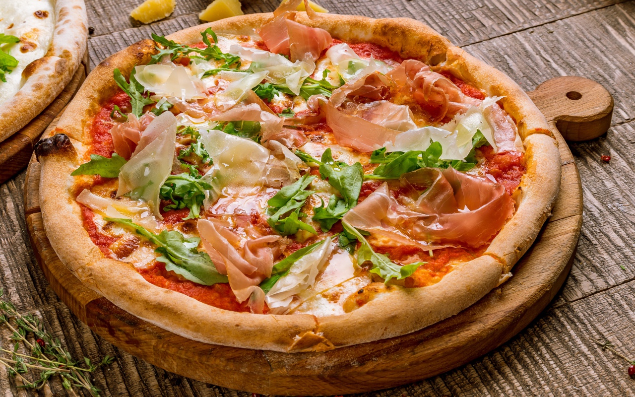 Пицца с рыбой и рукколой  на разделочной доске 