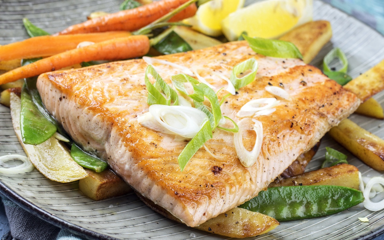 Запеченная красная рыба с овощами на тарелке