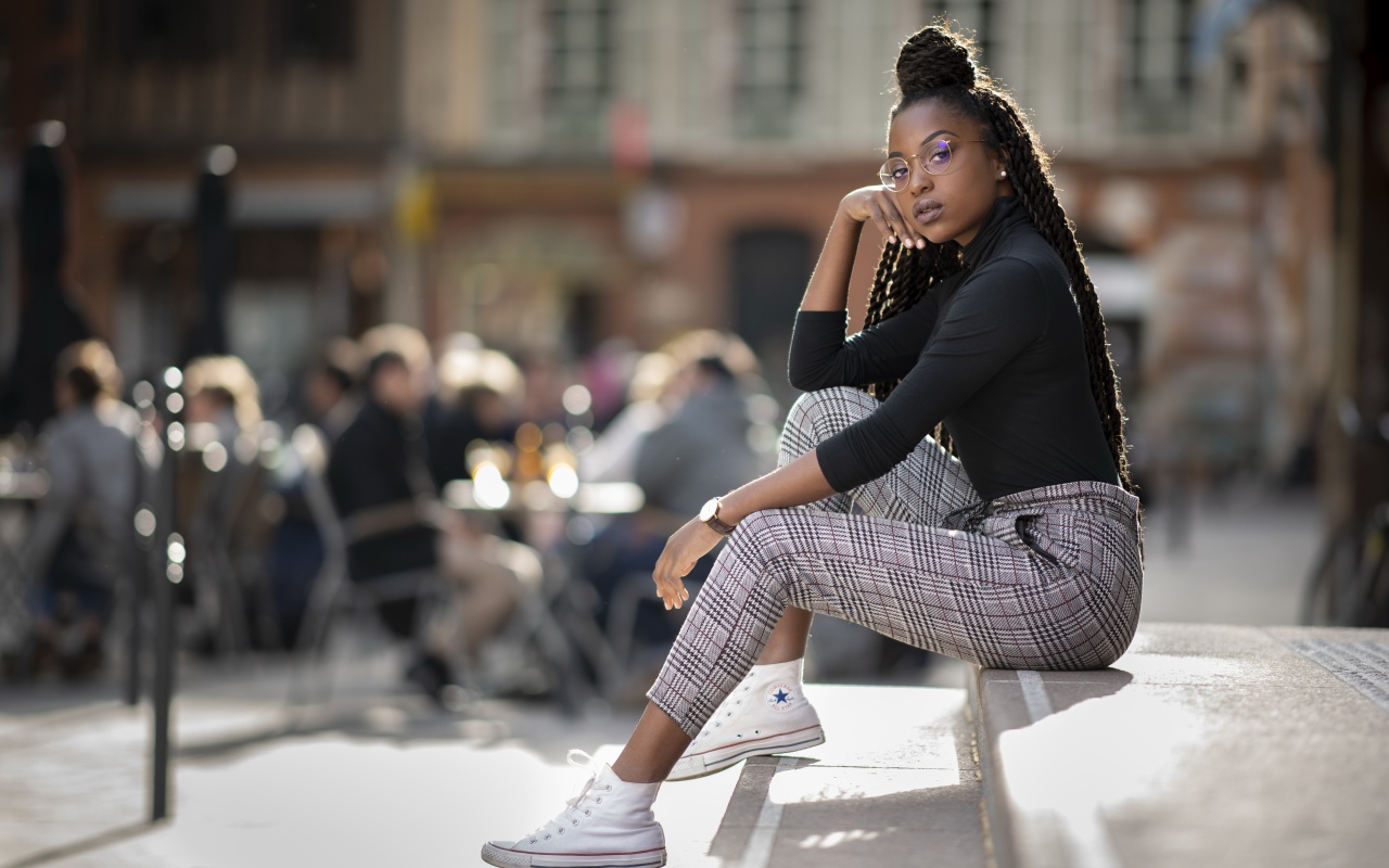 Красивая темнокожая девушка сидит на ступеньках