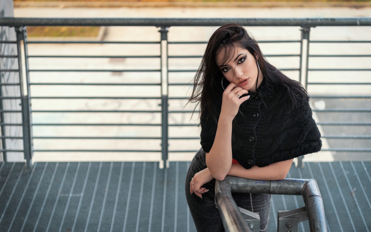 Красивая девушка стоит на ступеньках у перил 