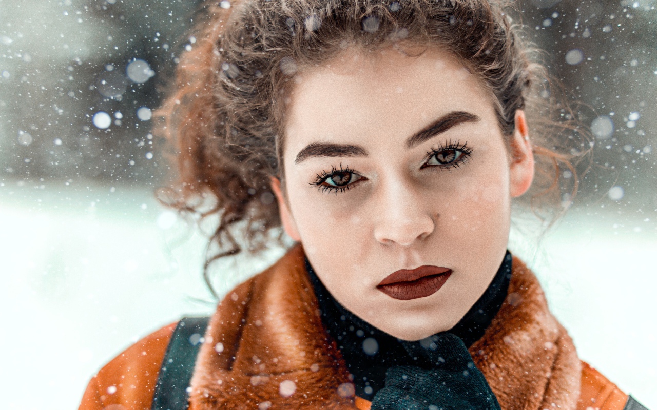Красивая кареглазая девушка стоит на улице зимой