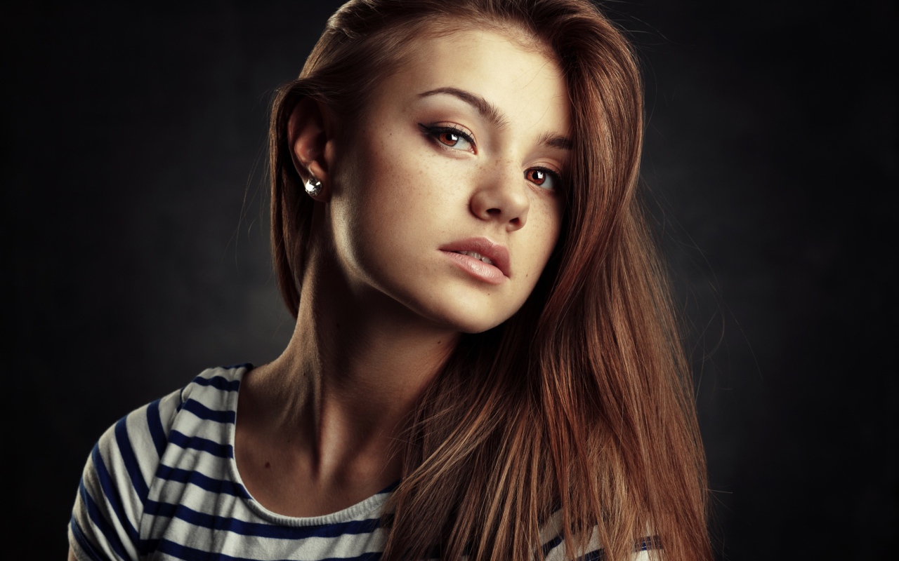 Красивая кареглазая девушка с русыми волосами на сером фоне