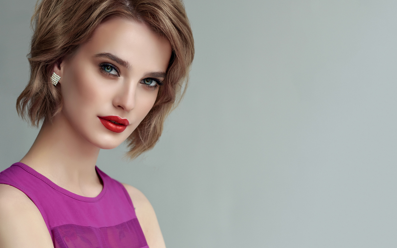 Красивая девушка шатенка с короткой стрижкой на сером фоне