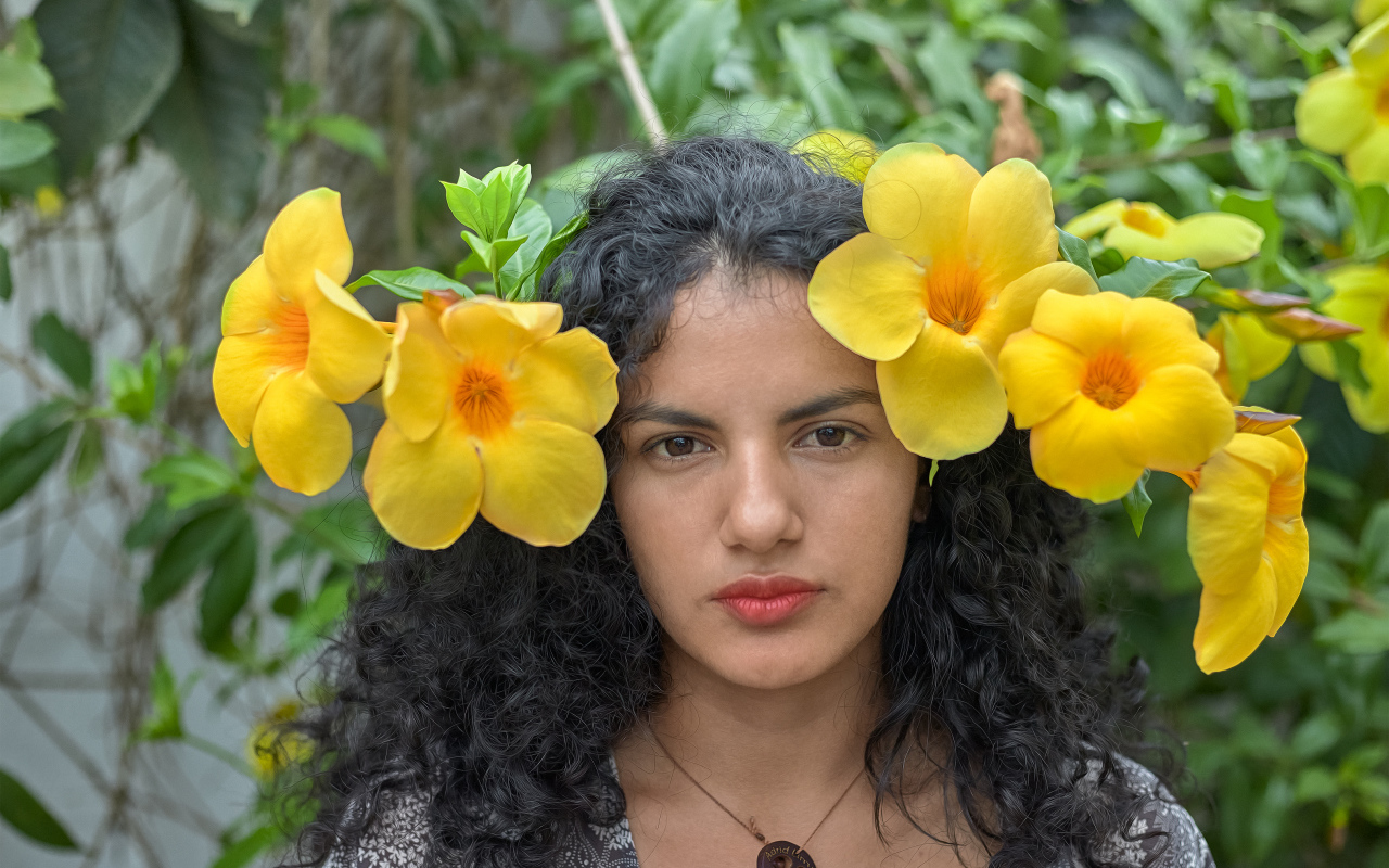 Красивая брюнетка с большими желтыми цветами в волосах 