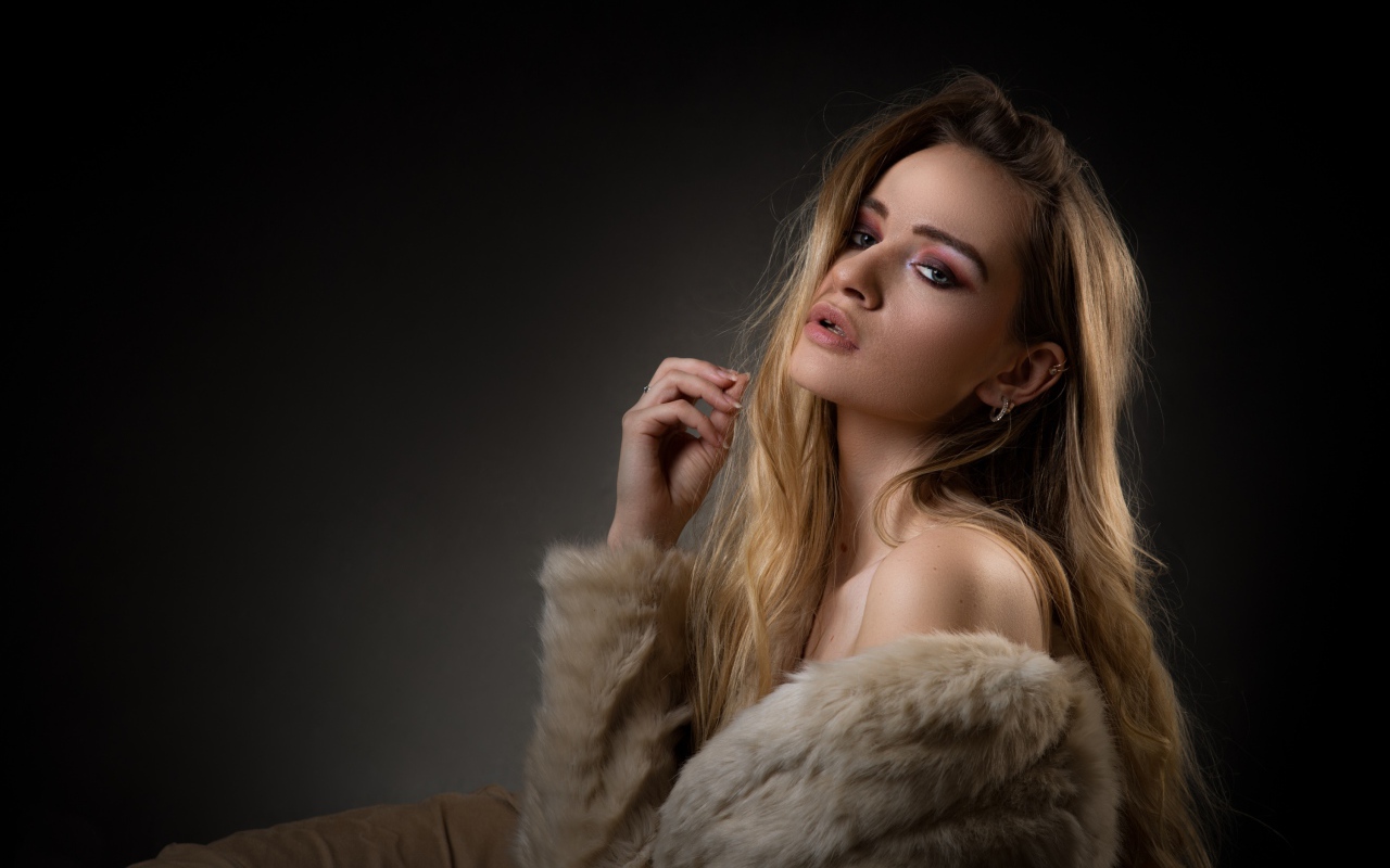 Красивая девушка в шубе на сером фоне