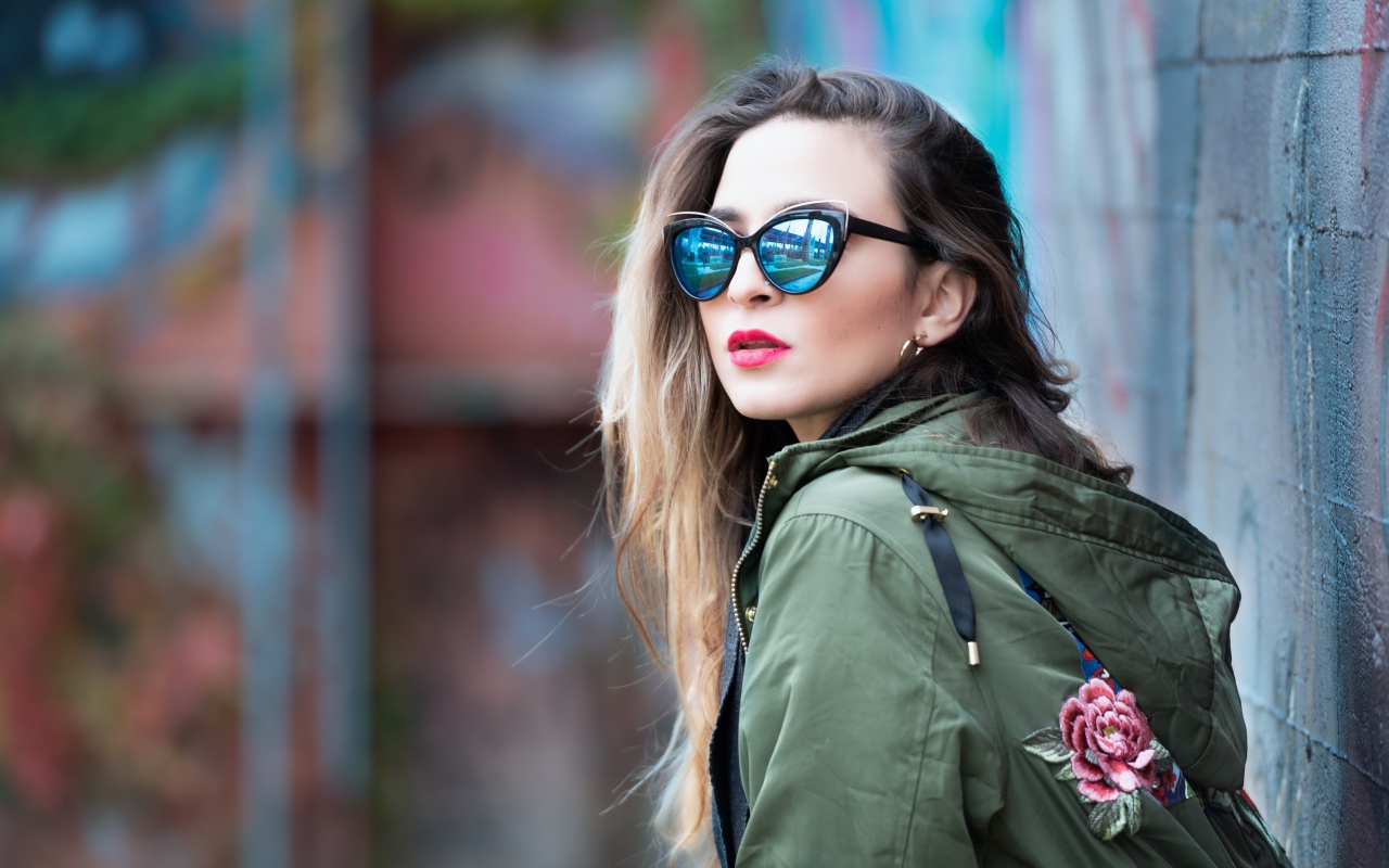 Красивая девушка в куртке и солнечных очках