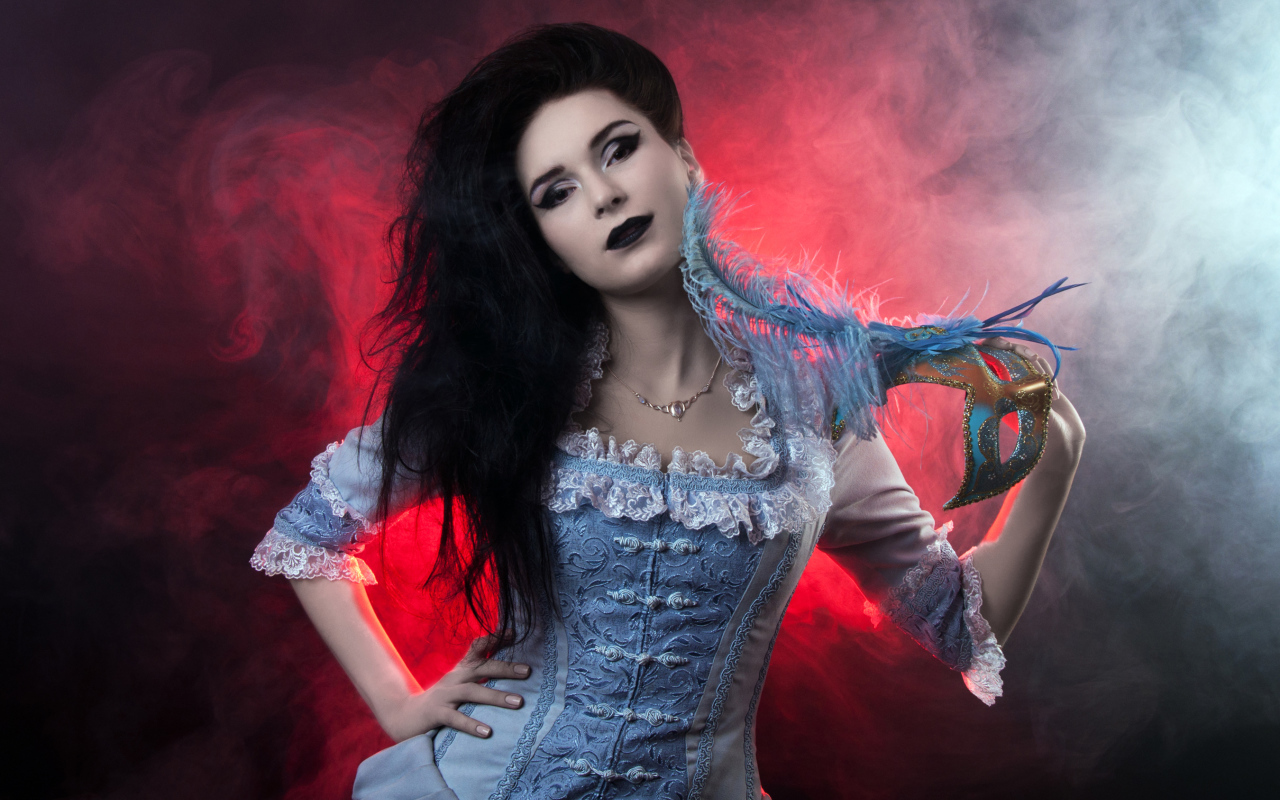 Красивая девушка в старинном платье с маской в руке