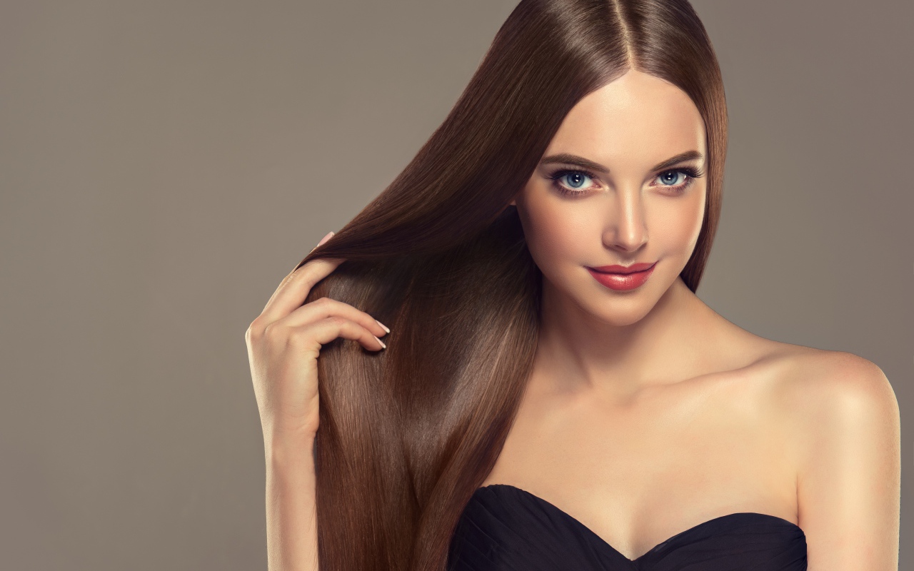 Красивая нежная длинноволосая голубоглазая девушка на сером фоне