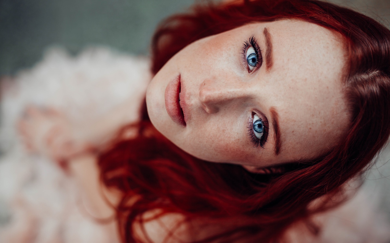 Голубоглазая рыжеволосая девушка с веснушками на лице