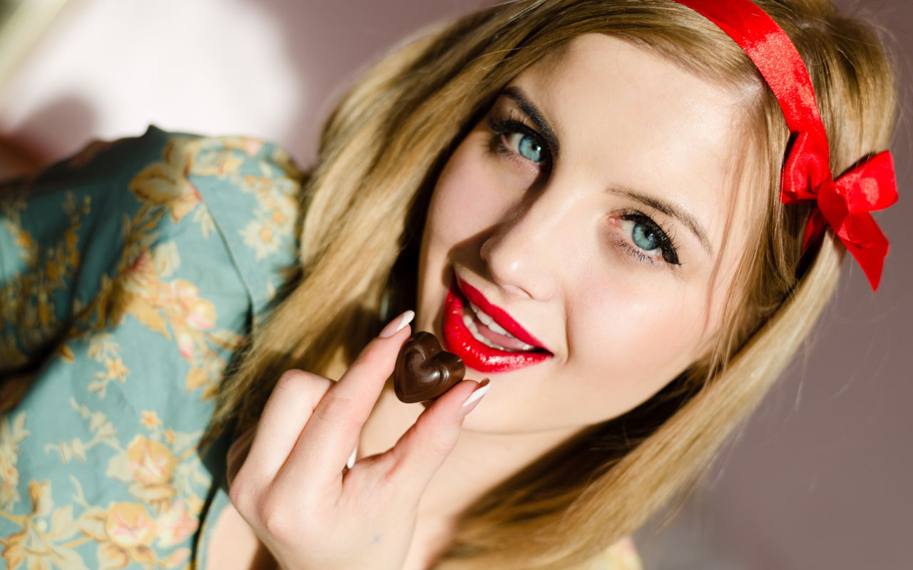 Яркая голубоглазая девушка с шоколадной конфетой 