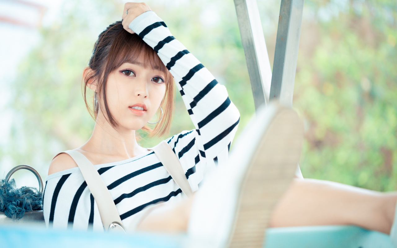 Кареглазая девушка азиатка в полосатом свитере