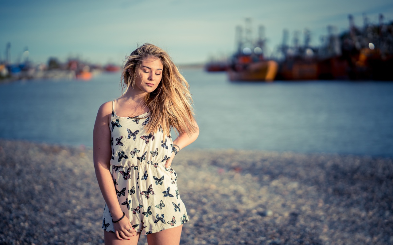 Милая блондинка на фоне моря в порту