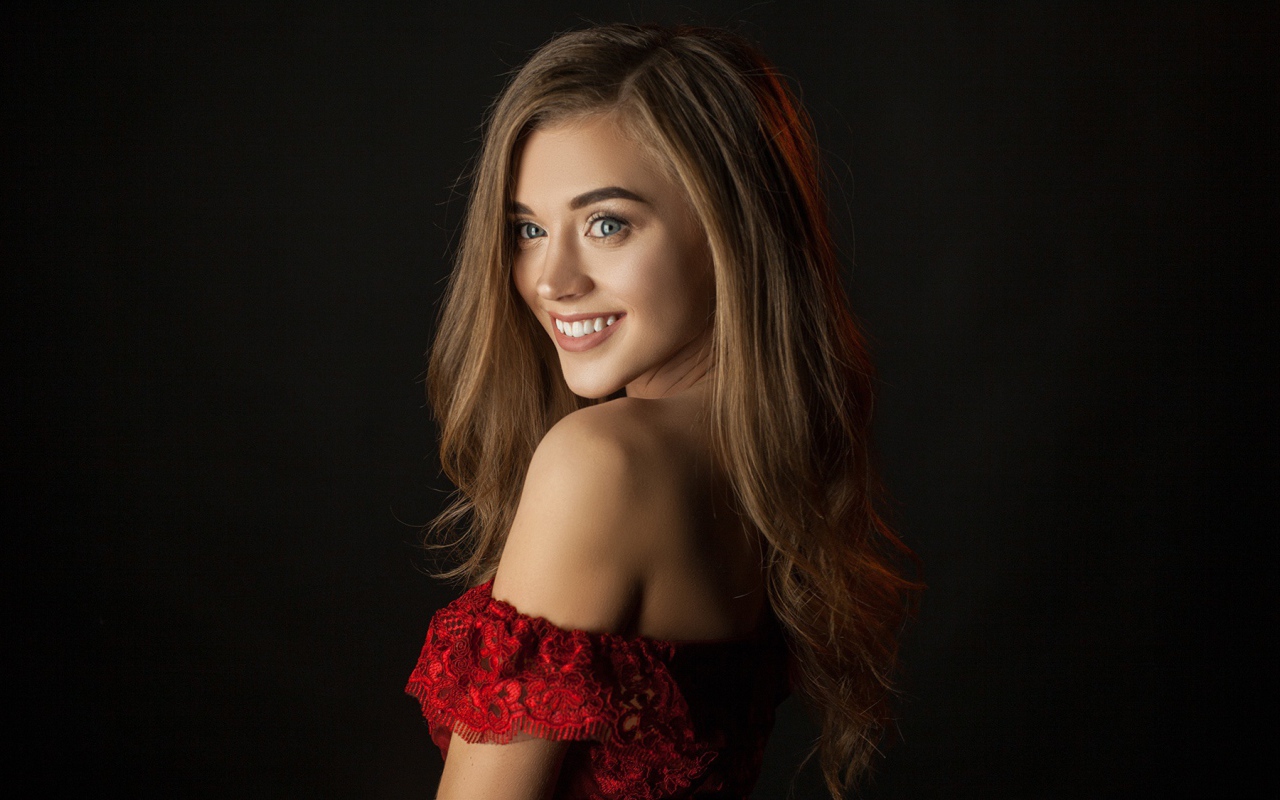 Милая улыбающаяся девушка на черном фоне