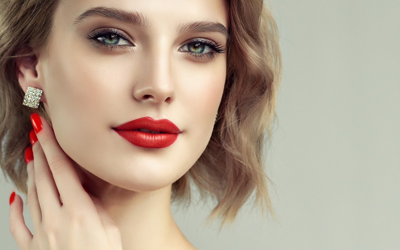 Лицо девушка с красивым макияжем на сером фоне