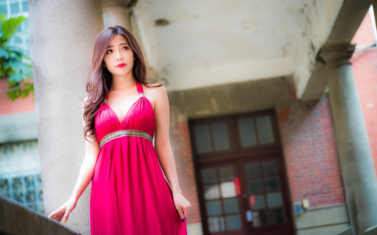 Девушка в красивом розовом платье у здания