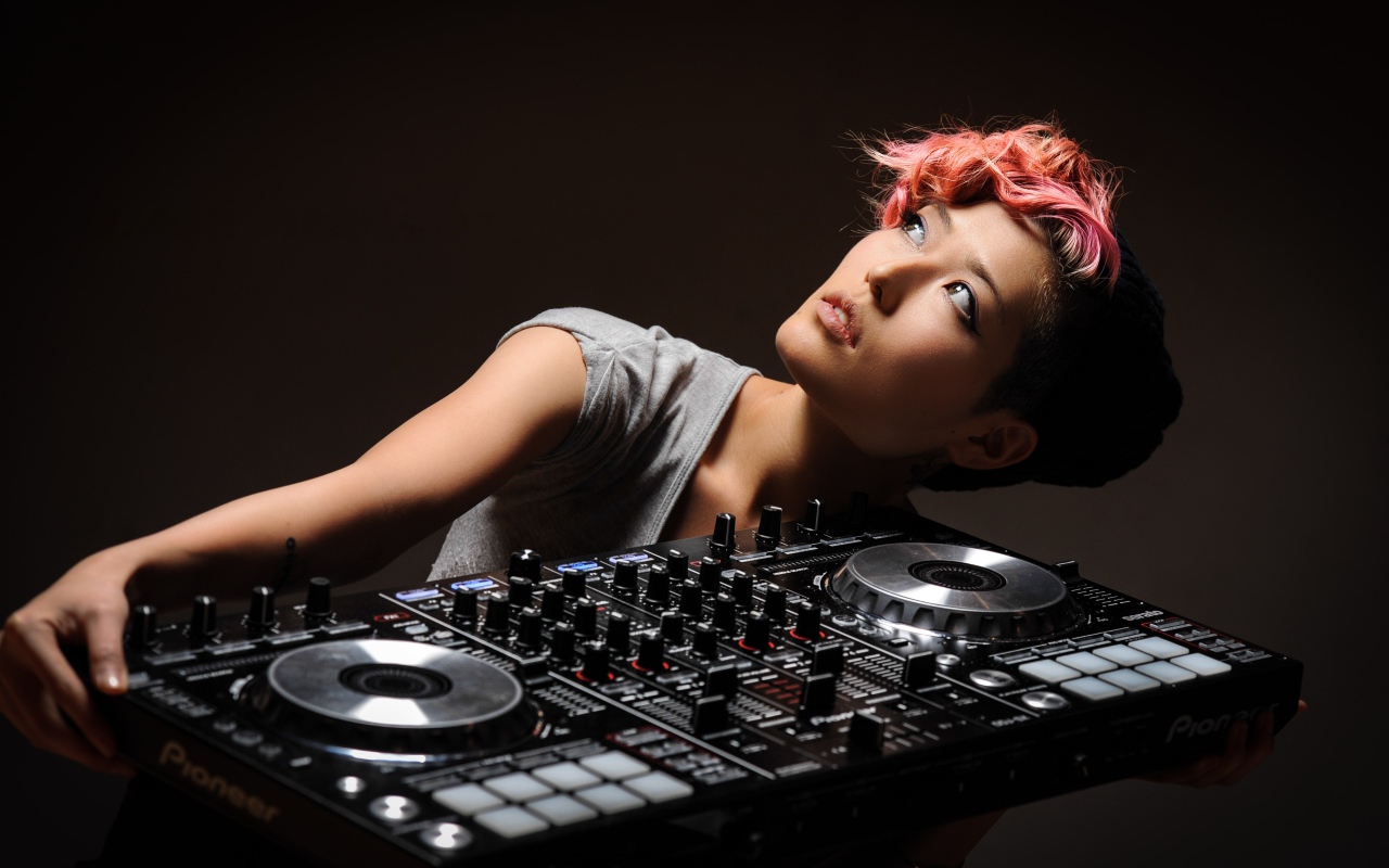 Девушка с розовой челкой с диджейским пультом в руках