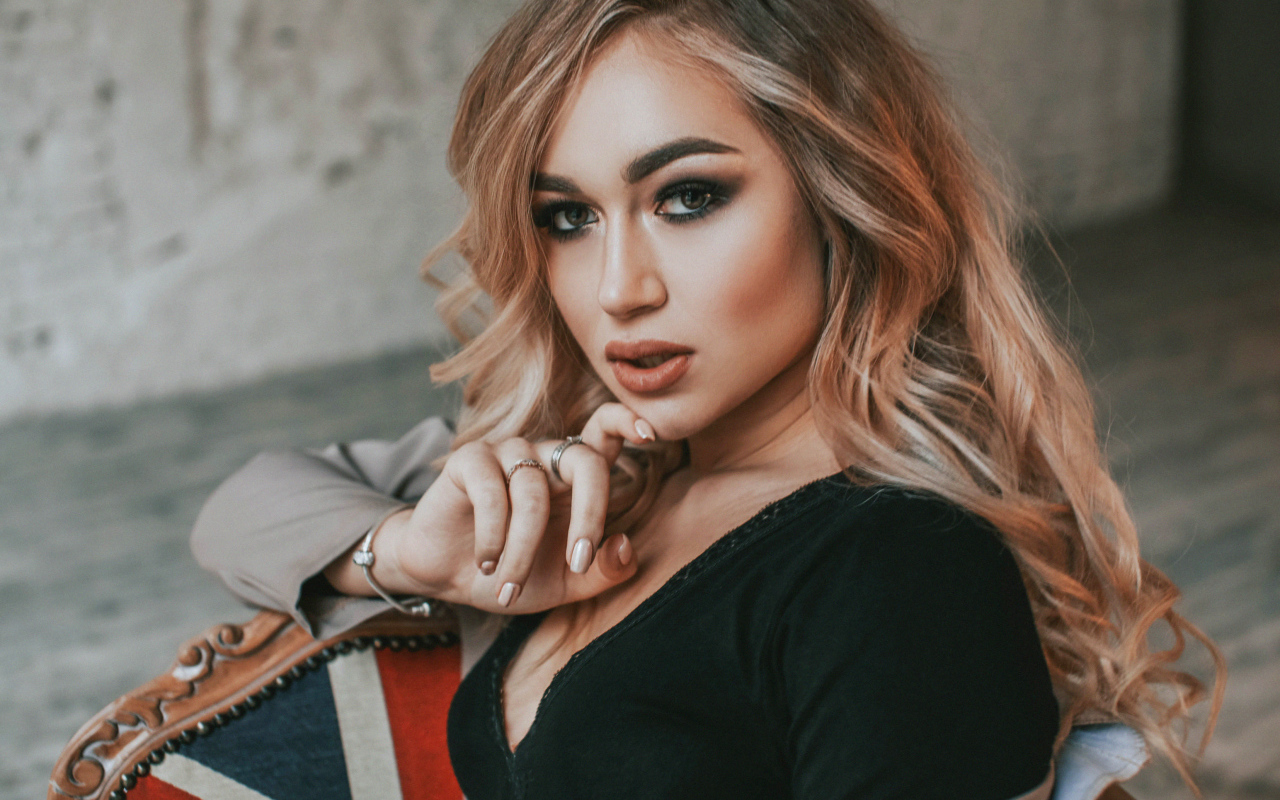 Горячая девушка с макияжем сидит на стуле