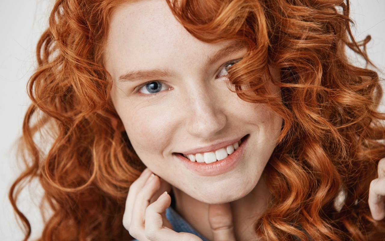 Улыбающаяся рыжеволосая девушка лицо крупным планом
