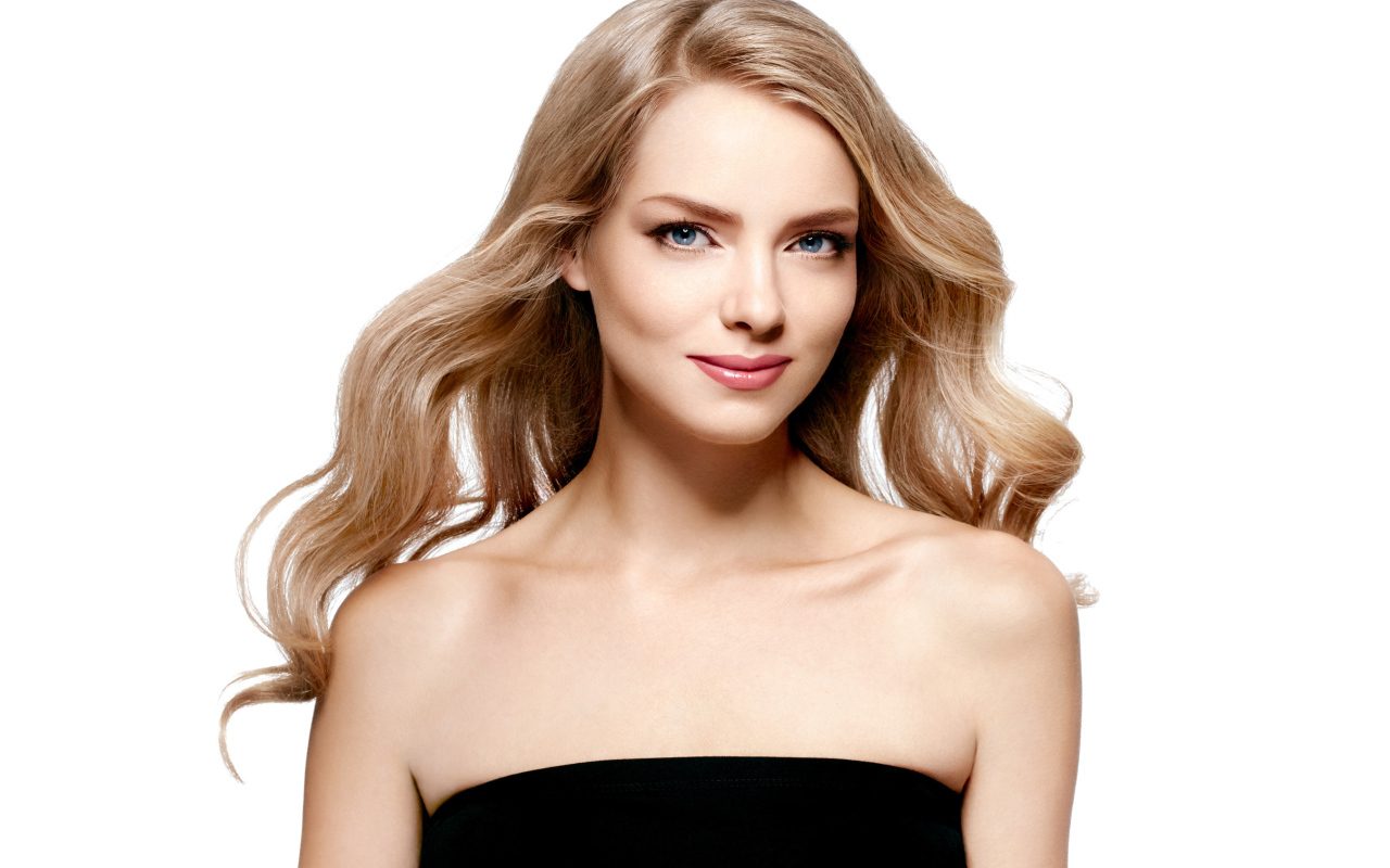 Нежная голубоглазая блондинка в черном платье на белом фоне