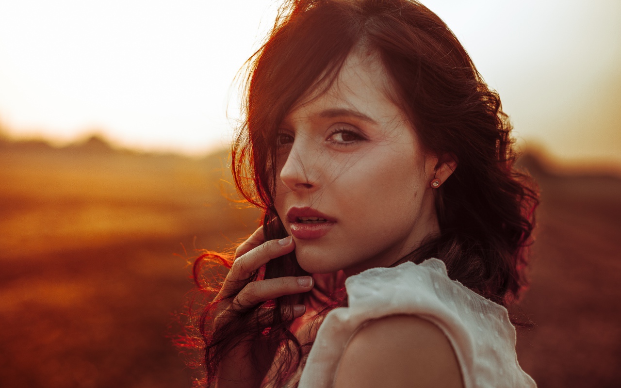 Ветер развивает волосы молодой девушки 