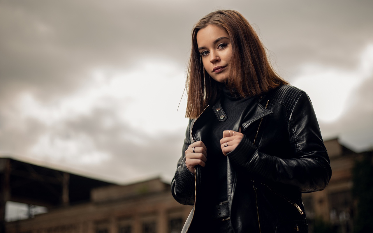 Молодая девушка в кожаной куртке на фоне грозового неба