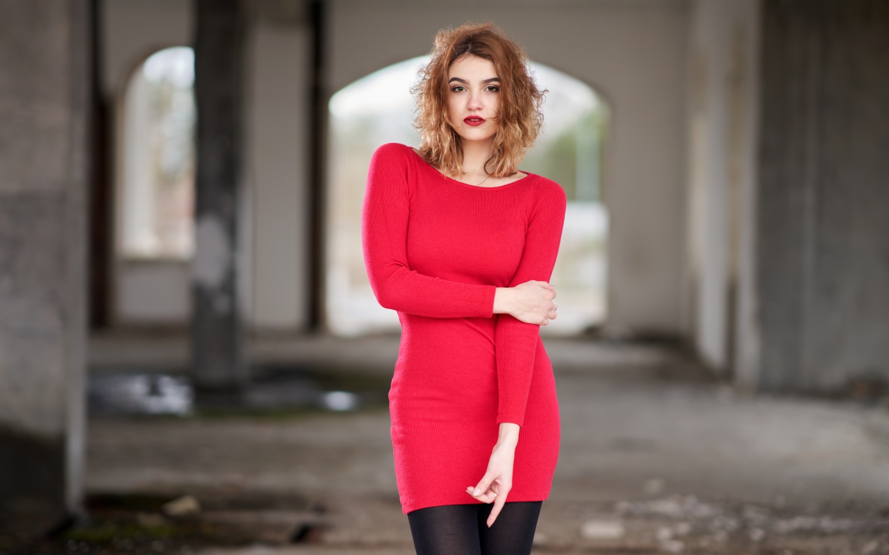 Молодая девушка в красном платье в старом здании