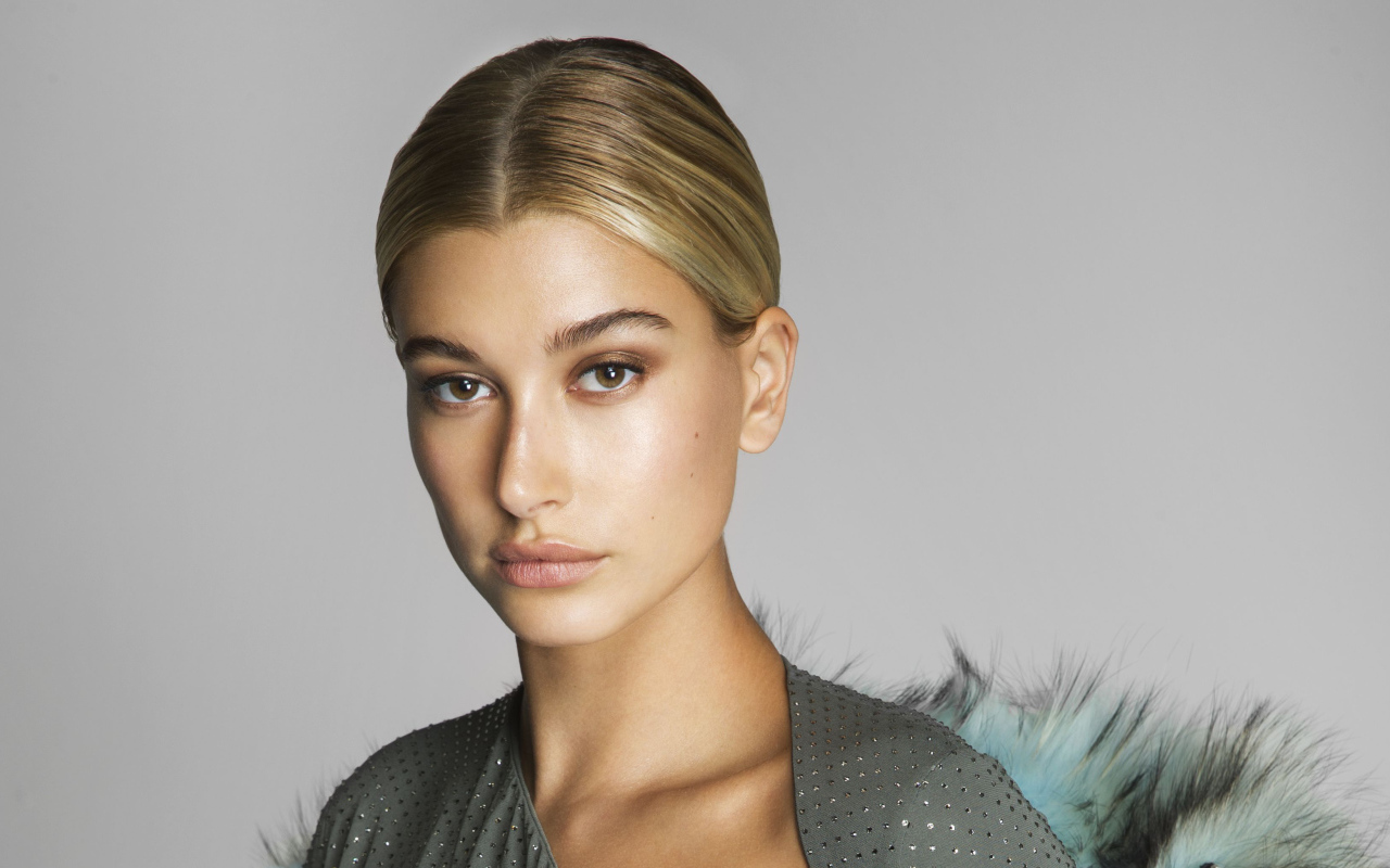 Серьезная блондинка, модель Хейли Болдуин на сером фоне