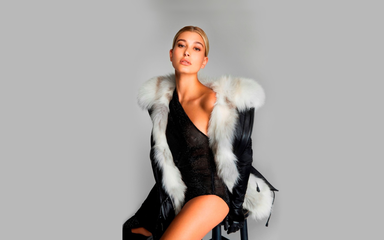 Эффектная модель Хейли Болдуин сидит на стуле на сером фоне