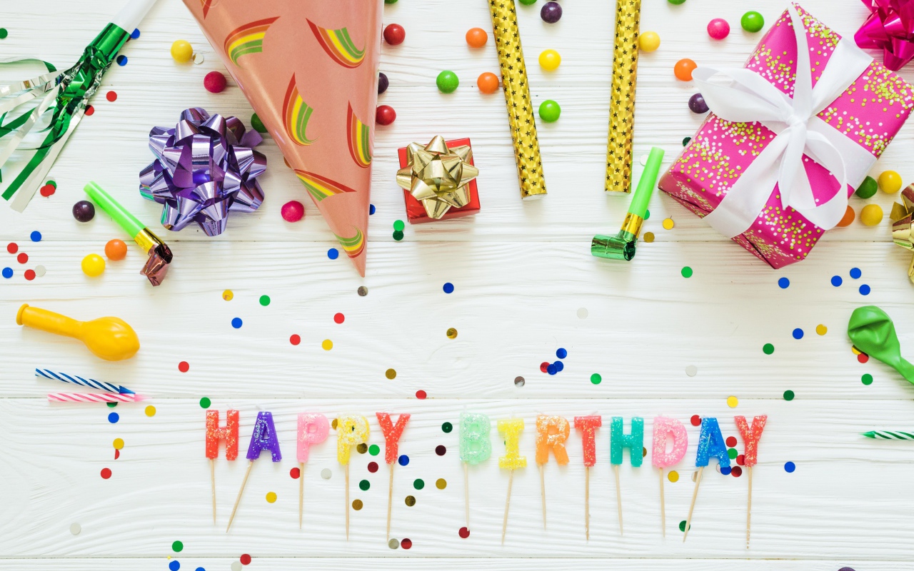 Надпись с Днем рождения на столе с подарками и украшениями